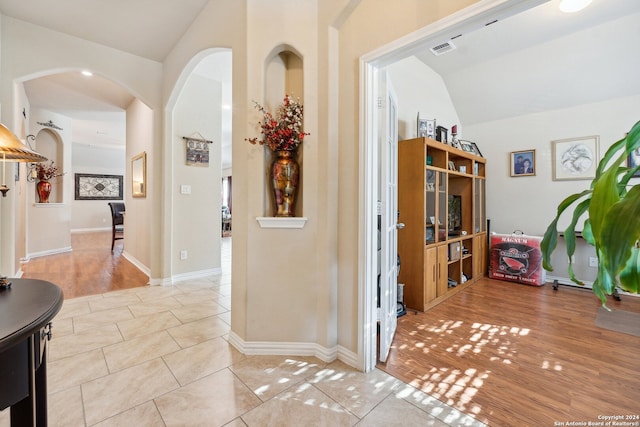 5018 Italica Rd, San Antonio, TX 78253 - corridor featuring visible vents, arched walkways, vaulted ceiling, baseboards, and light wood-style floors