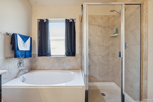 bathroom with plenty of natural light and separate shower and tub