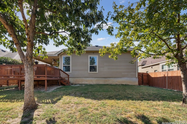 rear view of property with a wooden deck and a yard