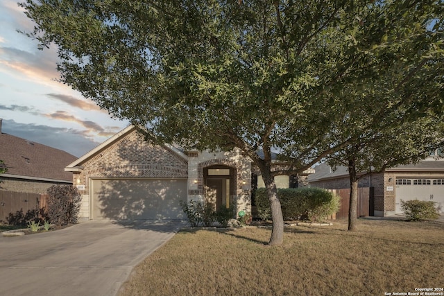 5018 Italica Rd, San Antonio, TX 78253 - view of property hidden behind natural elements with brick siding, a garage, a yard, and concrete driveway