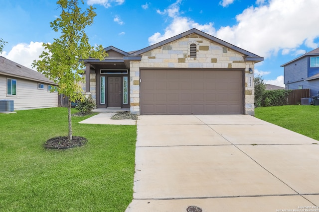 view of front of home with a garage, cooling unit, and a front lawn