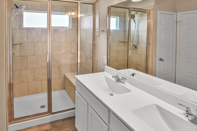 bathroom with hardwood / wood-style floors, a shower with door, and vanity