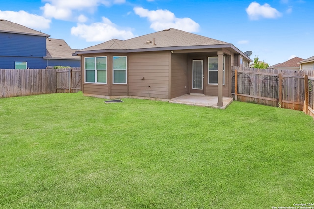 rear view of house featuring a yard and a patio area