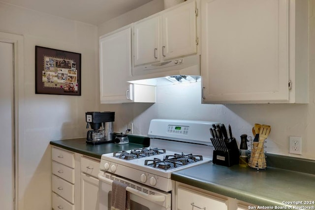 kitchen featuring white gas range oven and white cabinets