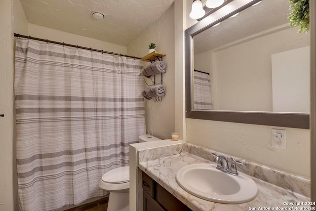 bathroom with vanity, toilet, a textured ceiling, and a shower with shower curtain