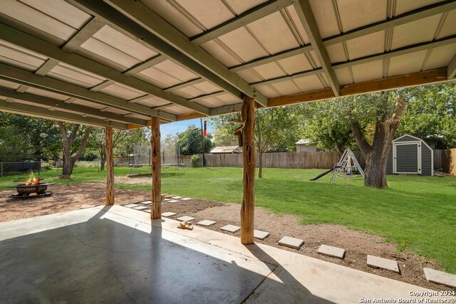 view of patio featuring an outdoor fire pit and a shed