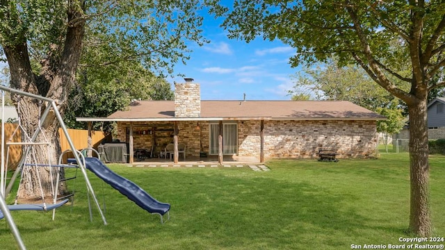 back of property featuring a playground, a patio, and a yard