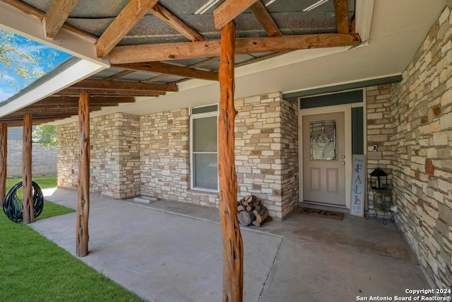 view of exterior entry with a patio