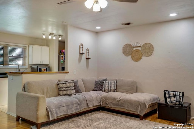 living room featuring light wood-type flooring and ceiling fan