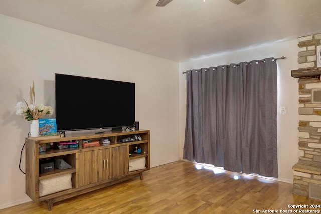 living room with light hardwood / wood-style flooring and ceiling fan