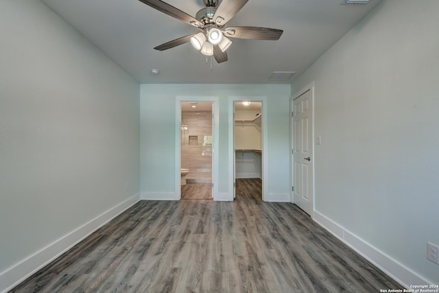 2293 W Mill St, New Braunfels, TX 78130 - unfurnished bedroom featuring baseboards, a spacious closet, wood finished floors, a closet, and ceiling fan