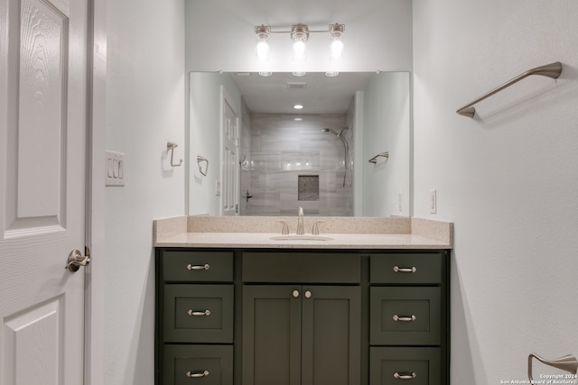 bathroom featuring a tile shower and vanity