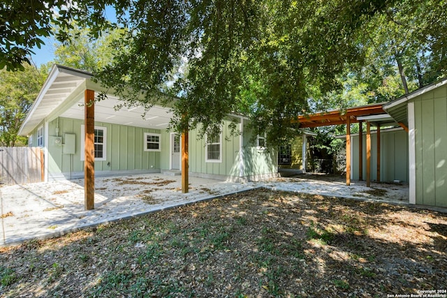 2293 W Mill St, New Braunfels, TX 78130 - rear view of property with board and batten siding and an attached carport
