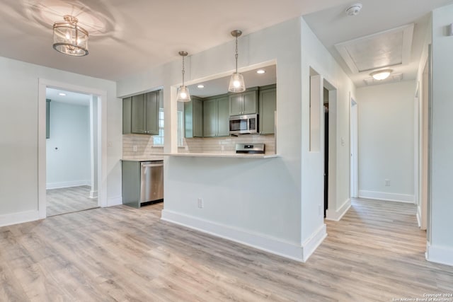 2293 W Mill St, New Braunfels, TX 78130 - kitchen with stainless steel appliances, green cabinetry, decorative backsplash, and light wood-style flooring
