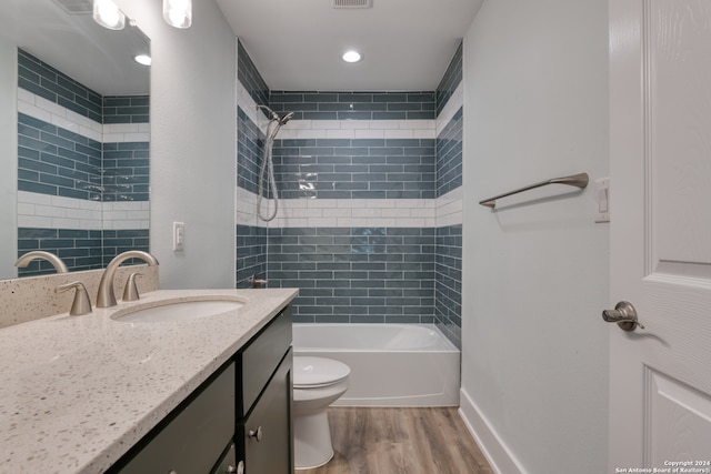 full bathroom featuring toilet, vanity, hardwood / wood-style floors, and tiled shower / bath