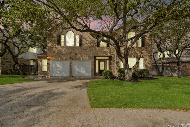 view of front of property with a garage and a yard