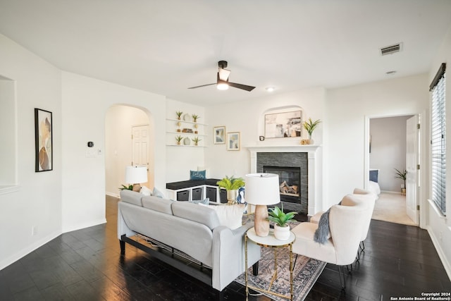 living room featuring a fireplace, ceiling fan, and dark hardwood / wood-style floors