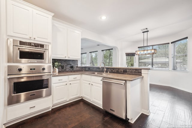 kitchen with stainless steel appliances, tasteful backsplash, sink, and white cabinetry