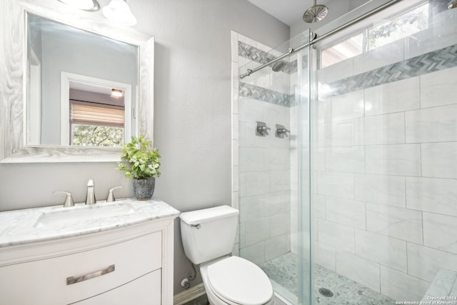 bathroom featuring vanity, toilet, and an enclosed shower