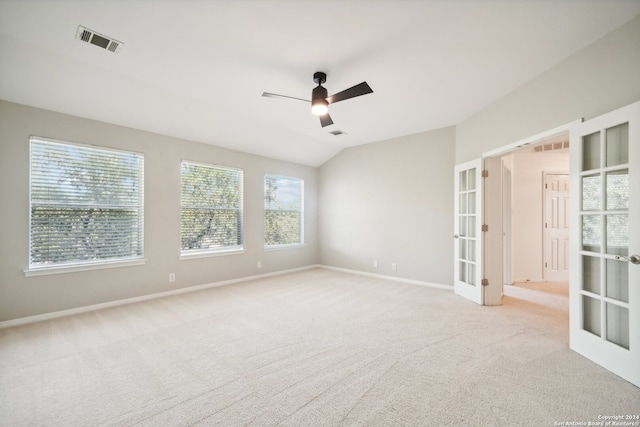 empty room featuring french doors, light colored carpet, vaulted ceiling, and ceiling fan