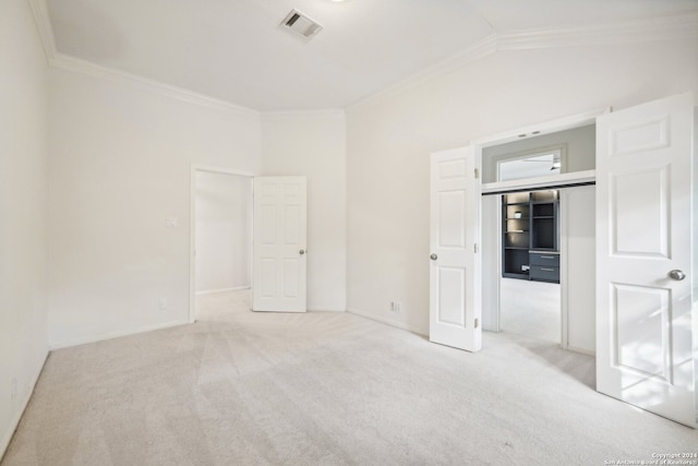 carpeted empty room with lofted ceiling and crown molding