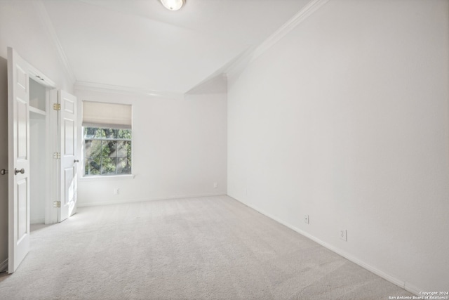 unfurnished room featuring ornamental molding and light carpet