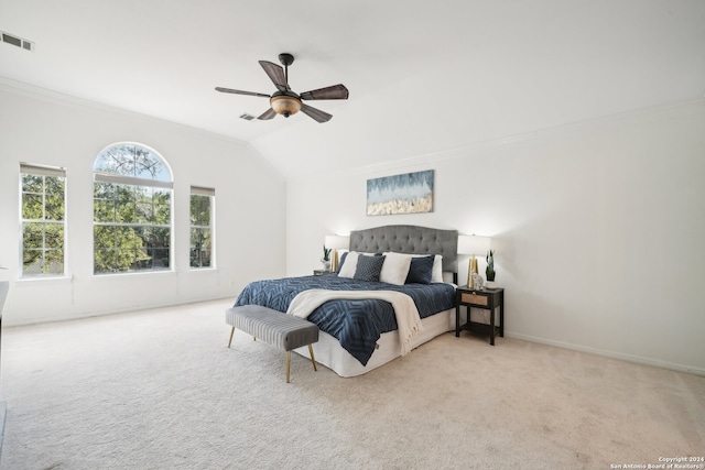 carpeted bedroom with ceiling fan, crown molding, and vaulted ceiling