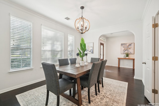 dining room with dark hardwood / wood-style floors, a chandelier, and ornamental molding