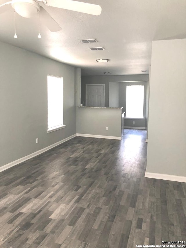 unfurnished room featuring ceiling fan and dark wood-type flooring