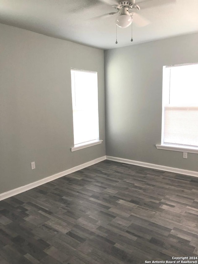 empty room with ceiling fan, dark hardwood / wood-style flooring, and a healthy amount of sunlight