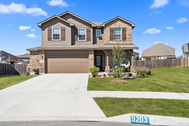 craftsman-style house featuring driveway, an attached garage, fence, a front yard, and brick siding