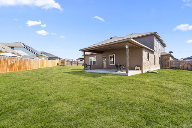 back of property featuring a patio area and a lawn