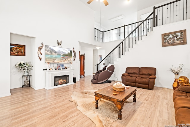 living room with a high ceiling, hardwood / wood-style flooring, and ceiling fan