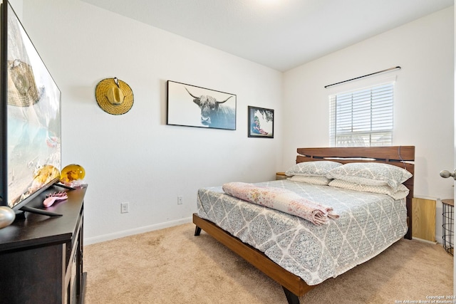 bedroom featuring baseboards and light carpet
