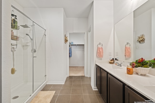 bathroom featuring tile patterned floors, vanity, and a shower with shower door