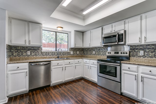 kitchen featuring stainless steel appliances, sink, dark hardwood / wood-style flooring, and white cabinetry