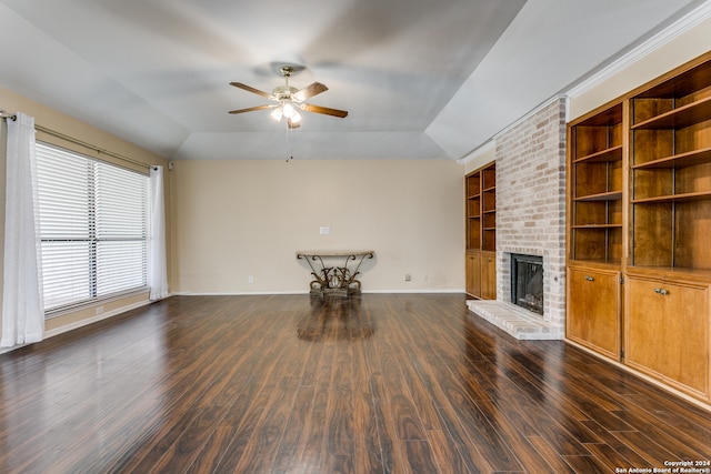 unfurnished living room with dark wood-type flooring, lofted ceiling, a fireplace, and ceiling fan