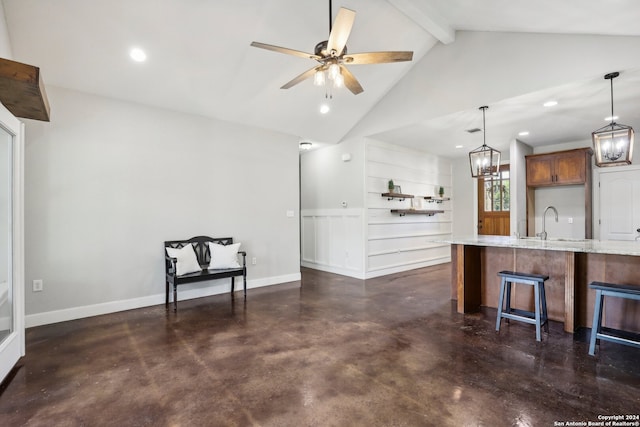 kitchen with light stone counters, ceiling fan, a breakfast bar, hanging light fixtures, and vaulted ceiling with beams