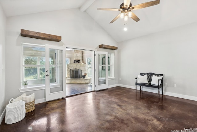 unfurnished room with ceiling fan, a stone fireplace, beamed ceiling, and high vaulted ceiling