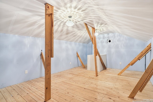 additional living space with light wood-type flooring and lofted ceiling