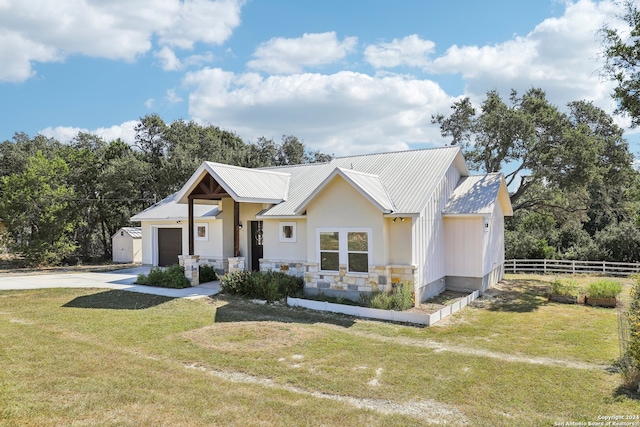 view of front of home featuring a garage, an outdoor structure, and a front lawn