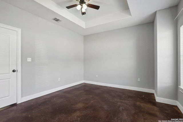 spare room featuring ceiling fan and a tray ceiling