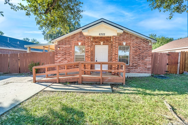 rear view of property featuring a wooden deck, a lawn, and a patio area