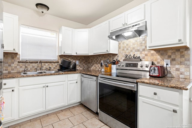 kitchen featuring appliances with stainless steel finishes, dark stone counters, white cabinetry, and backsplash