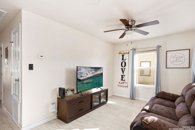 living room with light hardwood / wood-style flooring and ceiling fan