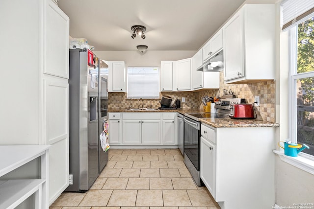 kitchen featuring tasteful backsplash, dark stone countertops, sink, appliances with stainless steel finishes, and white cabinetry