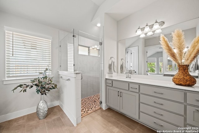 bathroom with a tile shower and vanity