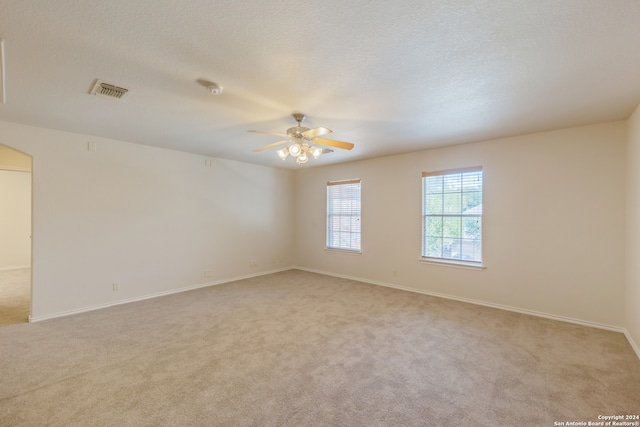 carpeted spare room with ceiling fan and a textured ceiling