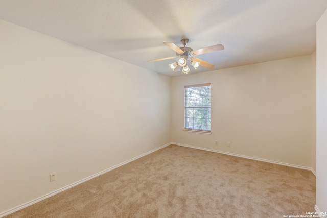 carpeted spare room with ceiling fan