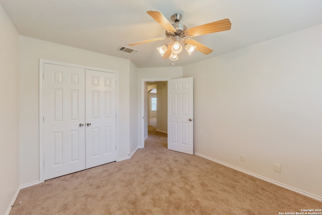 unfurnished bedroom with ceiling fan, a closet, and light colored carpet